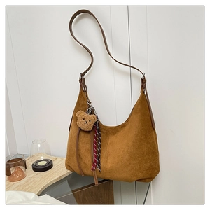 Brown suede hobo bag detailing with a cute plush bear charm and rope tassels