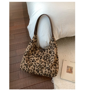 Vue détaillée de la texture peluche léopard et de la bandoulière en cuir brun du sac hobo
