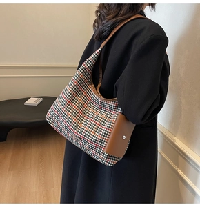 Close-up of houndstooth wool tote bag with brown leather trim and mini side pouch