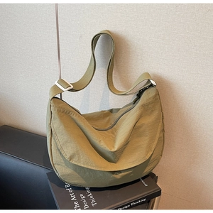 Detailed texture of olive green waterproof nylon fabric on a crossbody crescent bag