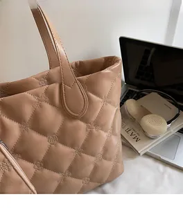 Close-up of khaki quilted tote bag with star pattern stitching and matching pouch