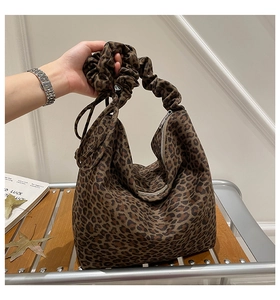 Close-up of leopard print tote bag with ruffled handle and silver zipper detail