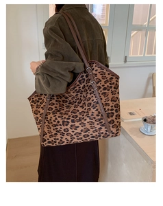 Detail of adjustable leopard print tote bag with brown leather strap and metal buckle