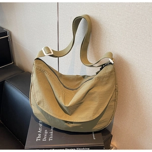 Detail of adjustable strap and olive nylon fabric on large crossbody crescent bag