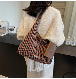 Detail of vintage houndstooth tote bag with brown leather strap and small accessory pouch