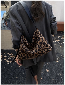 Chic hobo bag featuring leopard print knit texture and black leather shoulder strap