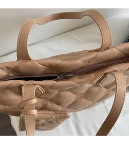 Close-up of the high-quality metal zipper and quilted leather texture on an apricot tote