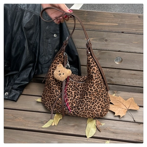 Leopard print canvas hobo bag with brown shoulder strap and cute bear charm detail