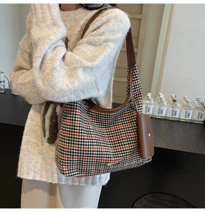 Detail of vintage houndstooth tote bag with brown leather strap and mini pouch