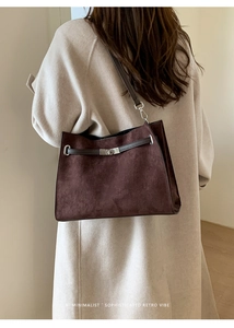 Detail view of large dark brown suede tote bag with silver clasp and leather strap