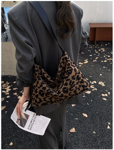 Photo en extérieur d'un grand sac hobo léopard avec bandoulière noire large