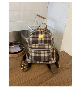 Detail of checkered mini backpack featuring golden zippers and luxury wool texture