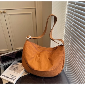 Detailed close-up of caramel nylon crescent bag with adjustable wide shoulder strap