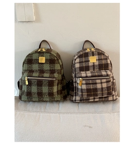 Detail shot of mini plaid backpacks in wool fabric featuring gold metal hardware