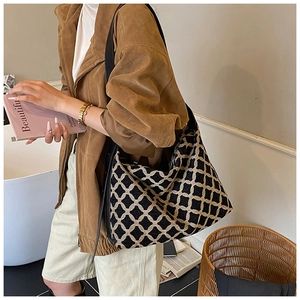Détail d'un grand sac hobo en jacquard avec motif géométrique et bandoulière en cuir