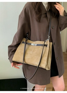 Close-up of minimalist faux suede tote bag featuring metallic turn-lock and leather straps