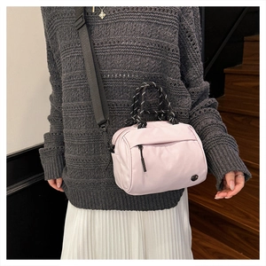 Detail of lavender nylon shoulder bag with woven rope handle and black strap