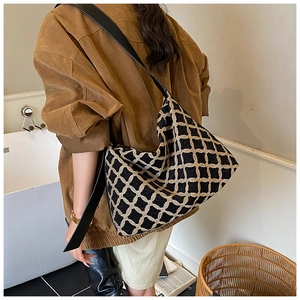 Détail de la large bandoulière en cuir noir et du sac cabas à motifs géométriques