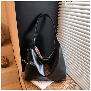 Detail of black Hobo tote bag showing white contrast stitching and smooth faux leather