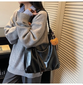 Close-up of black retro large capacity tote bag with cute bear charm and tassel detail