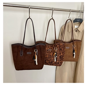 Detailed display of three tote bags with beaded charms and leopard print textures