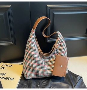 Detail of vintage houndstooth hobo bag featuring brown leather trim and a small pouch