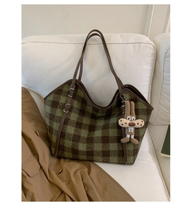 Detail of green plaid tote bag in textured wool with a cute plush bunny pendant