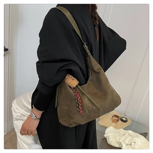 Detail of vintage suede hobo bag in olive green with a cute plush bear pendant