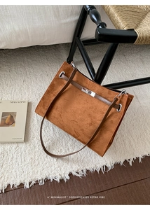 Detailed top view of a brown suede tote bag with a silver twist lock and slim straps