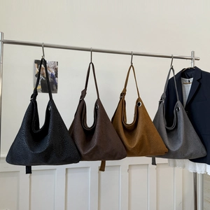 Large leopard embossed tote bags in four colors with knotted shoulder straps on a hanger