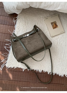 Close-up of olive green matte suede tote bag with silver twist lock and smooth leather trim