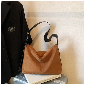 Vue détaillée du matériau en daim marron avec bandoulière en cuir et boucles dorées