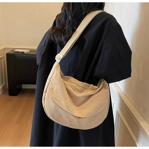Detail of khaki nylon crescent bag with adjustable wide strap and zipper closure
