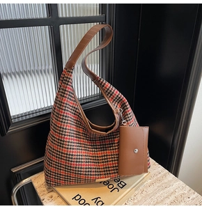 Detailed view of vintage houndstooth tote bag with brown leather straps and small pouch