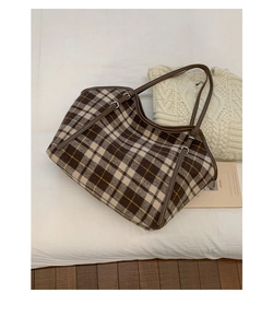 Detailed texture of a brown plaid tote bag in wool fabric with leather straps