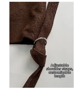 Detail of adjustable strap with polished silver metal ring on leopard pattern tote bag