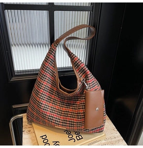 Close-up of vintage plaid tote bag with brown leather straps and a detachable coin purse