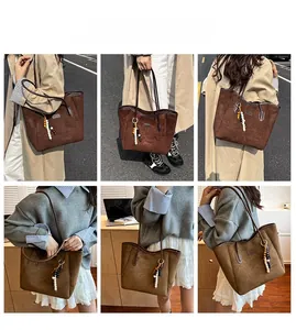 Detail of minimalist tote bags in coffee and khaki suede with a beaded tassel charm
