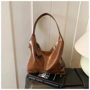 Close-up of brown vintage hobo bag made of high-gloss oil wax leather with wide strap