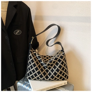 Détail du sac cabas tissé à motif géométrique avec bandoulière sur une valise