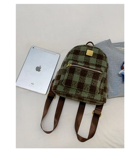 Detail shot of a fuzzy plaid backpack in green and brown with premium gold hardware