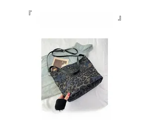 Detail of leopard print canvas bucket bag with adjustable leather strap and metal buckle
