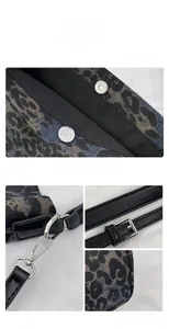 Detail view of silver magnetic clasp and adjustable strap on leopard print canvas tote bag