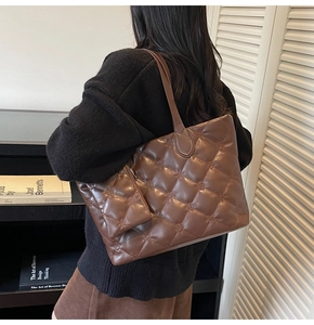 Detail of coffee quilted tote bag with diamond pattern and matching mini pouch on shoulder