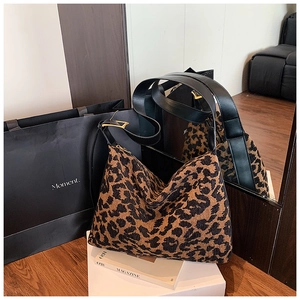 Détail du sac hobo à imprimé léopard avec bandoulière en cuir noir et boucle dorée