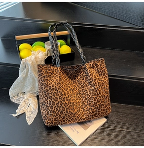 Close-up of leopard print tote bag with black rope handles on a wooden staircase