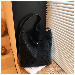 Detail of black leopard print hobo bag showing textured fabric and leather corner reinforcement