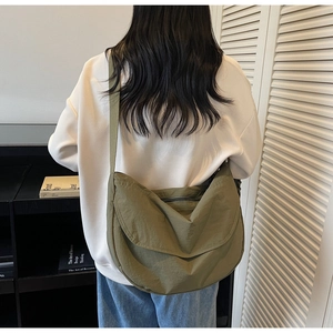 Close-up of olive green nylon crescent bag with adjustable wide strap and smooth texture