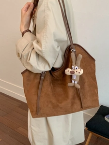 Large brown suede tote bag with leather straps and cute bunny charm pendant on shoulder