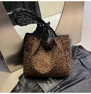 Detailed close-up of leopard print suede tote with stylish black braided handles
